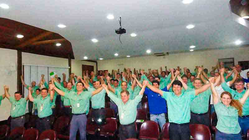 Equipe Vale com os braços para cima na palestra motivacional